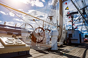Sailship deck with helm, rigging and cables.