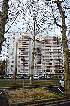 Saint-Etienne, France - January 27th 2020 : Focus on cyan and orange modern buildings with a park