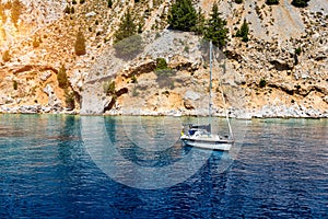 Saint George bay on Symi island, popular stop over for tourists to have a swim in the turquoise waters, Symi island, Greece. Boat