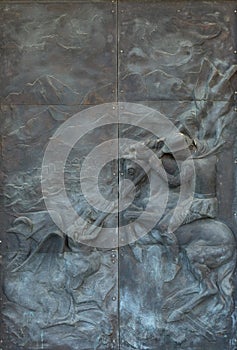 Saint George slaying the dragon, door of the Saint Peter Catholic Cathedral in Bar, Montenegro