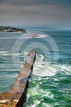 Saint Jean de Luz, France. Basque country. City views Ciboure and Castle and port of Socoa. Ocean waves breaking about the dam