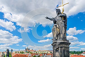 Saint John the Baptist statue on Charles Bridge Karluv Most over Vltava river with Prague Castle