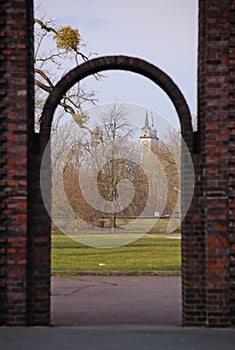 Saint Johns Church in Magdeburg seen through arch of the horse gate in Rotehornpark