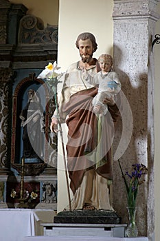 Saint Joseph holds a baby Jesus