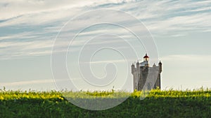 Saint Julian Fortress lighthouse behind grassland, Oeiras, Lisbon