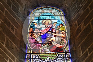 SAINT JUNIEN, FRANCE - DECEMBER 30, 2020: Stained glass windows in the church with Jesus Christ and people asking for healing