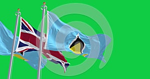 Saint Lucia and United Kingdom flags waving isolated on green background