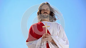 Saint man holding wooden cross, praying to God, religious sects concept, baptism