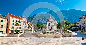 Saint Marko cathedral and church at Makarska city, Croatia. The Biokovo mountains in the background. Sunny day at summer, green