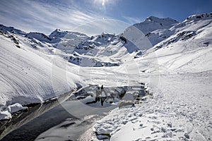 The snow-covered mountain and its reflection in Lac du Lou near Val Thorens resort photo