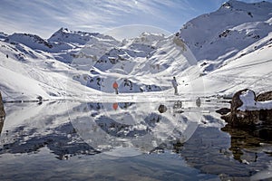 The snow-covered mountain and its reflection in Lac du Lou near Val Thorens resort photo