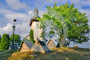 Saint Martin’s Church in Martincek with wooden marquises around during summer sunset