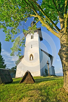 Saint Martin's Church in Martincek with wooden marquises around during summer sunset
