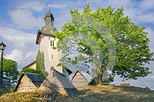 Saint Martin's Church in Martincek with wooden marquises around during summer sunset