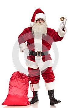 Saint nick holding bell stands near presents bag photo