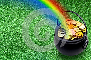 Saint Patrick`s Day and Leprechaun`s pot of gold coins concept with a rainbow indicating where the leprechaun hid treasure on