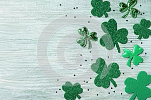 Saint Patricks Day background with green shamrock on white rustic board top view.