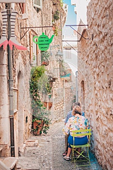 Saint-Paul-de-Vence, Provence / France - September 28, 2018: A couple of tourists in a small cozy cafe