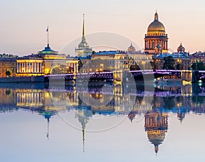 Saint Petersburg cityscape with St. Isaac`s cathedral, Admiralty building and Palace bridge at sunset reflected in Neva river, Rus