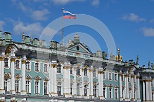 Sunny day in Saint-Petersburg, russian flag flying above facade of Hermitage State Museum