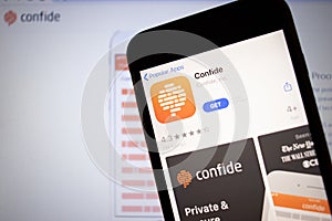 Saint-Petersburg, Russia - 10 January 2020: Mobile phone with Confide icon on screen close up with website on laptop, Illustrative
