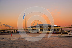 SAINT PETERSBURG, RUSSIA - MARCH 23, 2024: Cable-stayed bridge and Gazprom Arena Football Stadium against the sunset photo