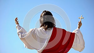 Saint prophet holding cross, praying to God, preaching Christianity back view