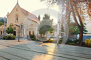 Kostol svätého Štefana večer, Bratislava, Slovensko. Žlté odlesky a tiene na chodníku pred slnečným žiarením