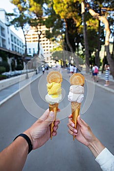 Saint Stephen, Montenegro, 07.07.2021: Beautiful bright ice cream with different flavors in the hands of a young couple in love.