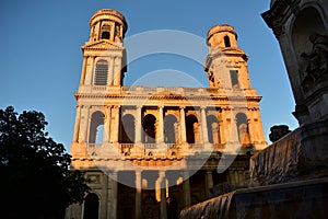 Saint Sulpice Church, Paris, France. Neoclassical facade with sunset light. Blue sky.