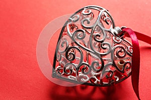 Saint Valentine day greeting card, beautiful silver heart with ribbon on red