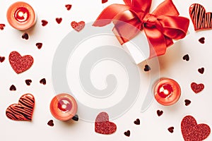 Saint Valentine day: red love hearts, romantic gift box, candle on white background. Romantic message template with copy space.