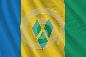 Saint Vincent and the Grenadines flag with big folds waving close up under the studio light indoors. The official symbols and