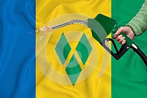SAINT VINCENT AND THE GRENADINES flag Close-up shot on waving background texture with Fuel pump nozzle in hand. The concept of