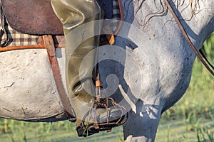 Rubber waders on a horse rider in the marshes of the Camargue photo