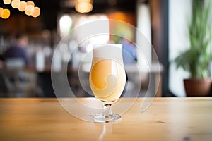 saison beer in a glass with a frothy head photo