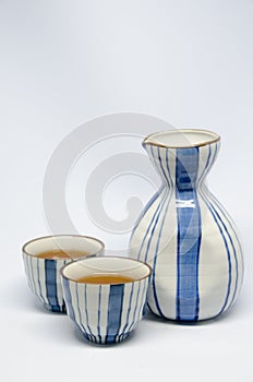 Sake bottle and cup on bright white background