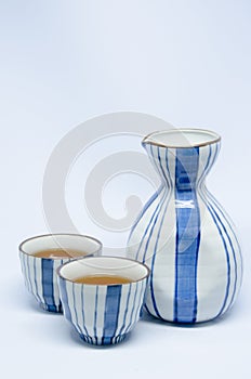 Sake bottle and cup on bright white background