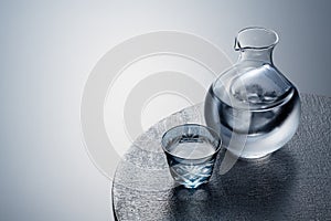 Sake poured into a faceted glass against a black background