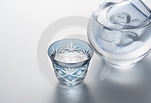 Sake poured into a faceted glass on a white background