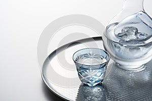 Sake poured into a faceted glass on a white background