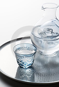 Sake poured into a faceted glass on a white background