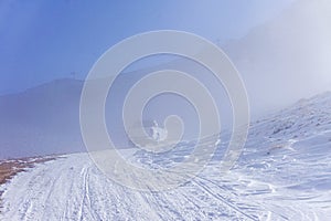 The white pick up truck is riding on snow at a foggy day in Antalya, Turkey