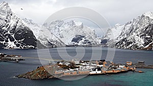 Sakrisoy island between snow covered mountains at the Reinefjorden on the Lofoten in Norway in winter