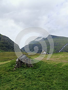 Saksun hills and stone structure with the white church in bacground , Eysturoy Island, Faroe Islands