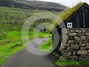 Saksun. Road and building of toilets with grass roof