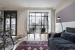 Living room with round glass dining table, gray designer chairs, large window photo