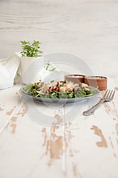 Salad with arugula, shrimps, parmesan cheese and pine nuts