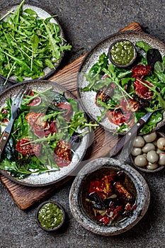 Salad with arugula, spinach, dried tomato and ham serrano paleta iberica. Low carbs keto recipe