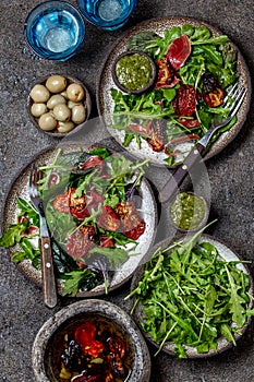 Salad with arugula, spinach, dried tomato and ham serrano paleta iberica. Low carbs keto recipe photo
